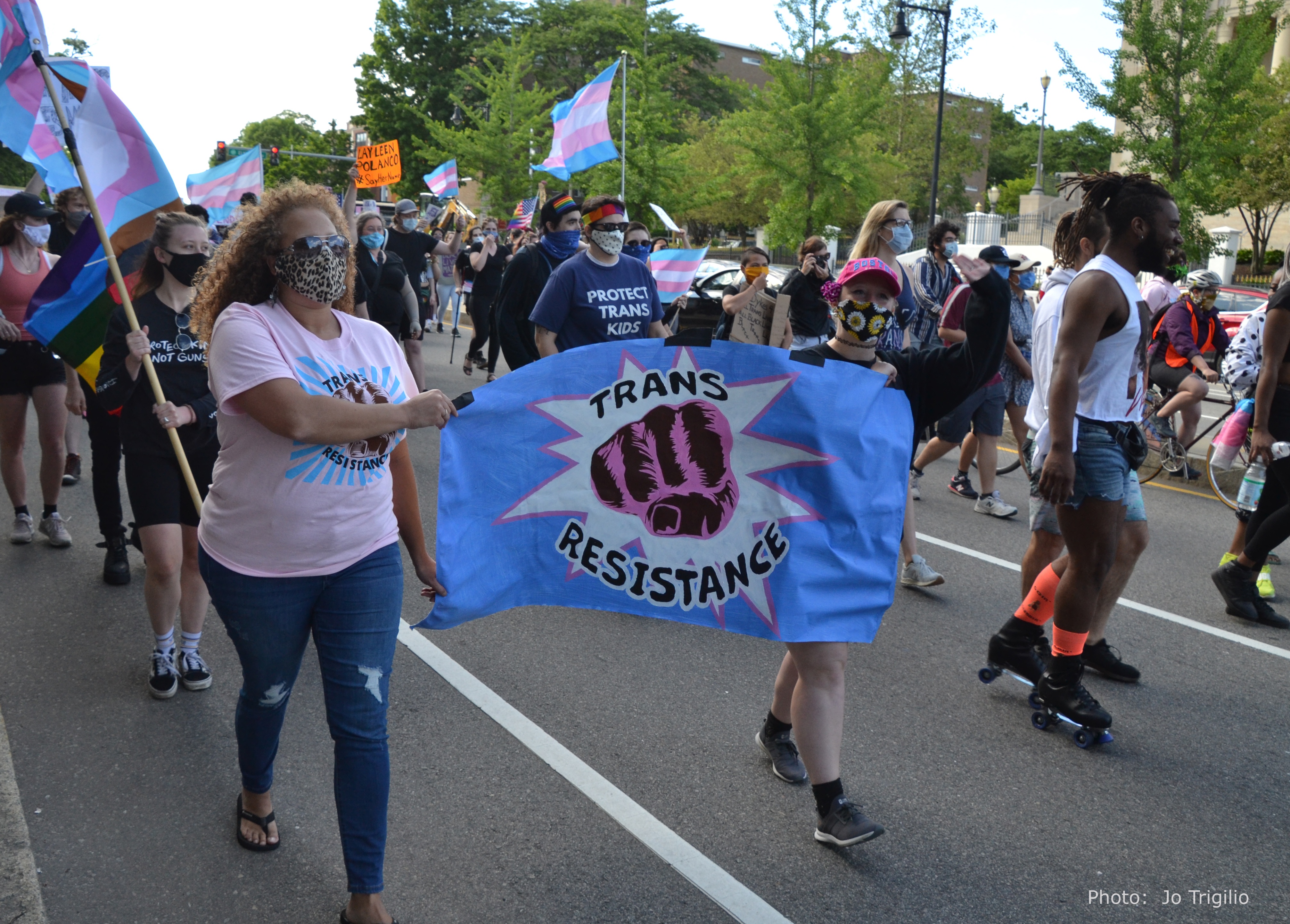 Protesters marching with TRANS RESTISTANCE banner, June 13, 2020 Trans Resistance March, Franklin Park, Boston. Photograph by Jo Trigilio.